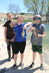 Three kids holding fish