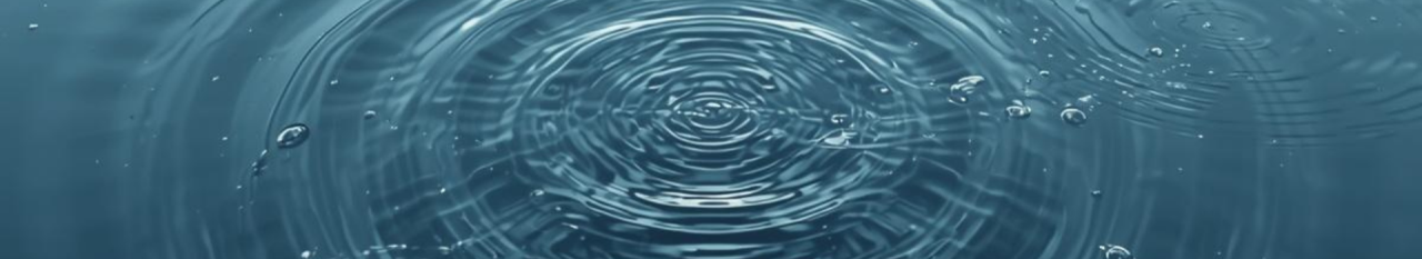 Concentric ripples on a deep blue water surface with light reflections.